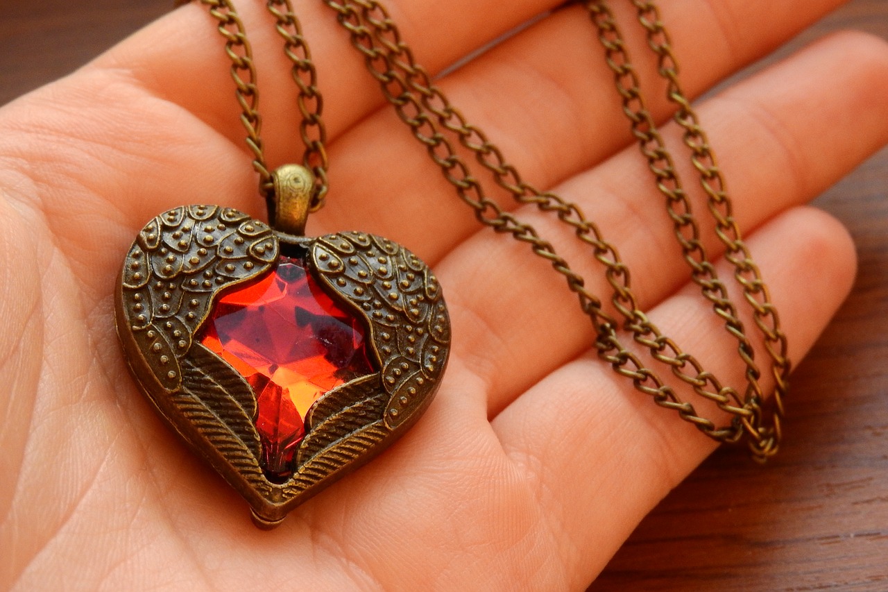 hand holding ruby heart jewelry necklace