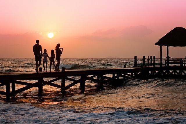 family on dock at sunset