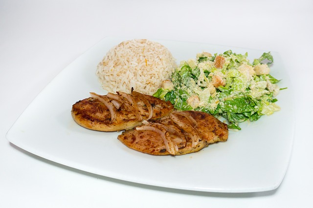 Healthy dinner of grilled chicken, brown rice and Caesar salad