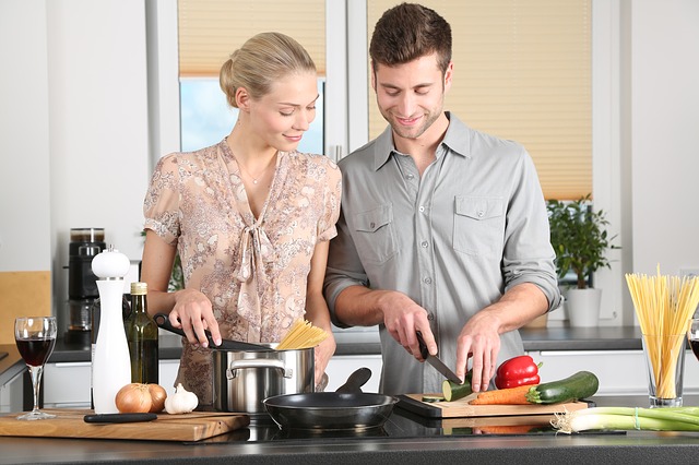 young man and woman cooking in home kitchen