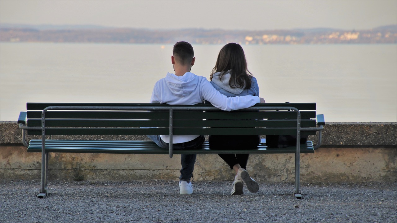 man and woman sitting on bench