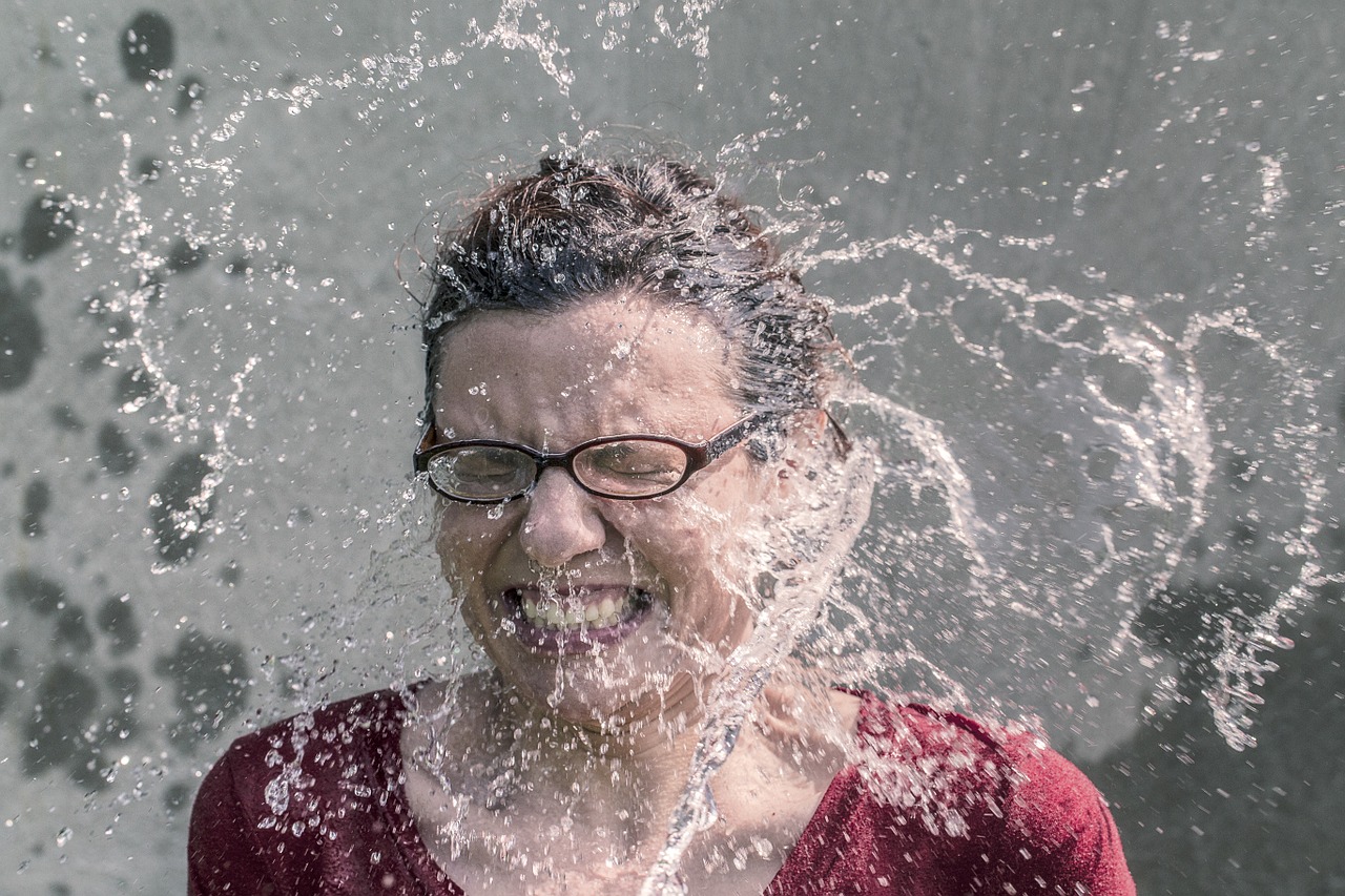 water splashing on surprised woman's face
