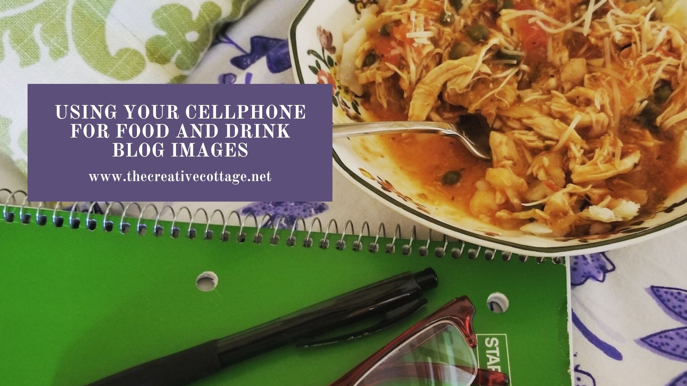 bowl of chicken cacciatore on table with green notebook and reading glasses