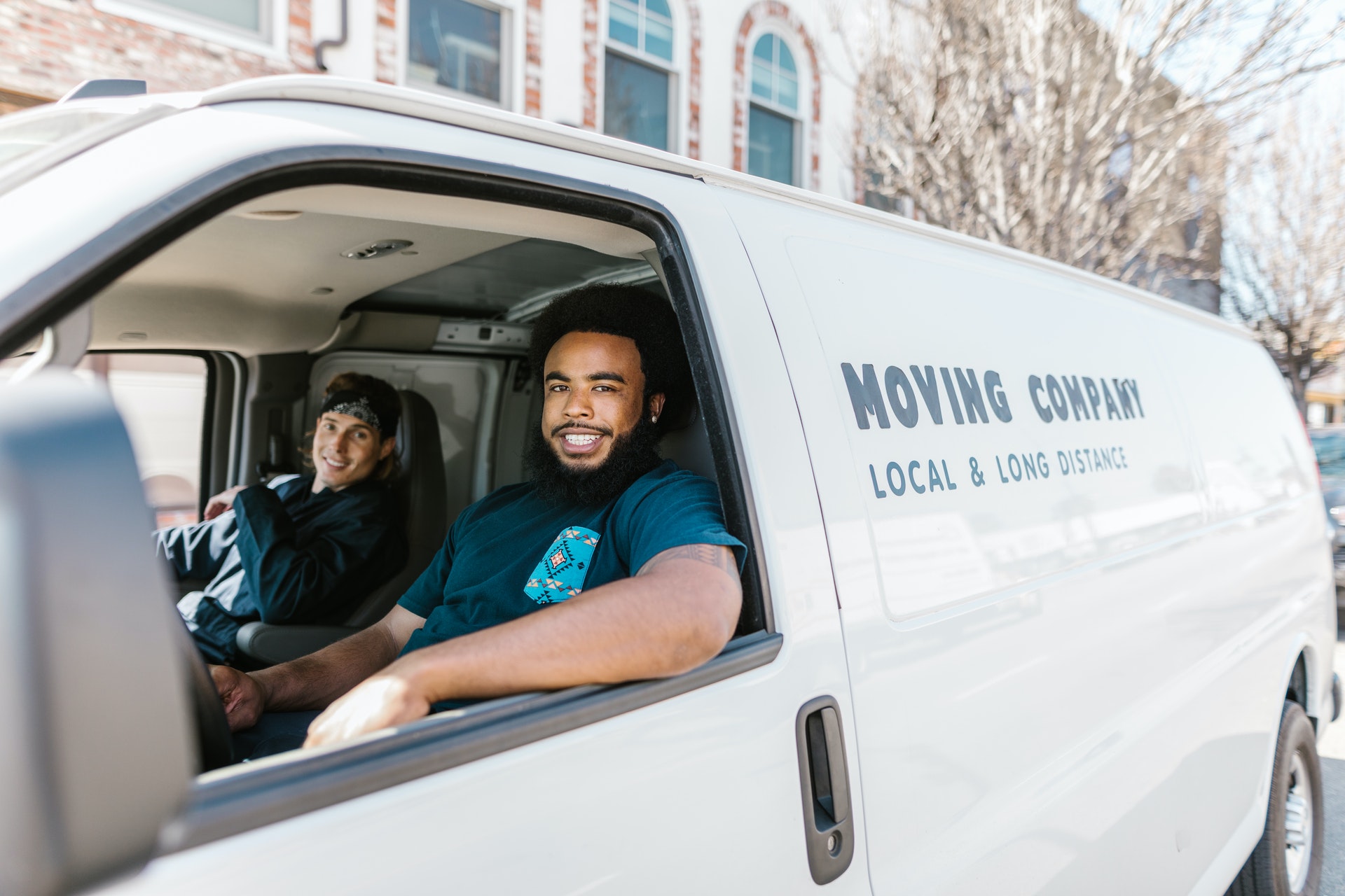 two men sitting in white moving van